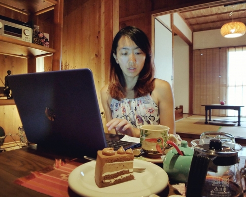digital nomad remote worker working in a cafe Asian