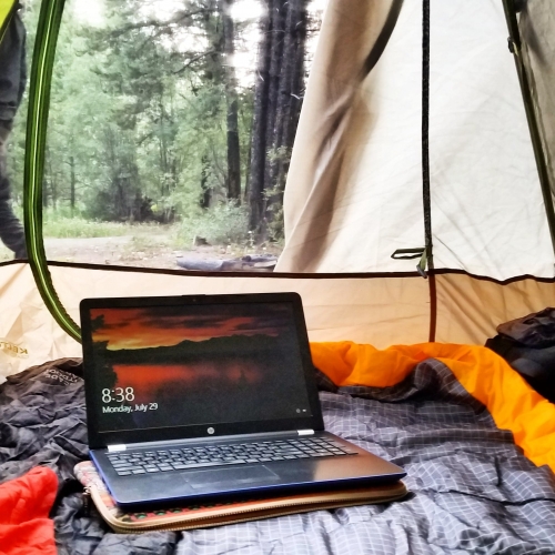 digital nomad remote working working in a tent