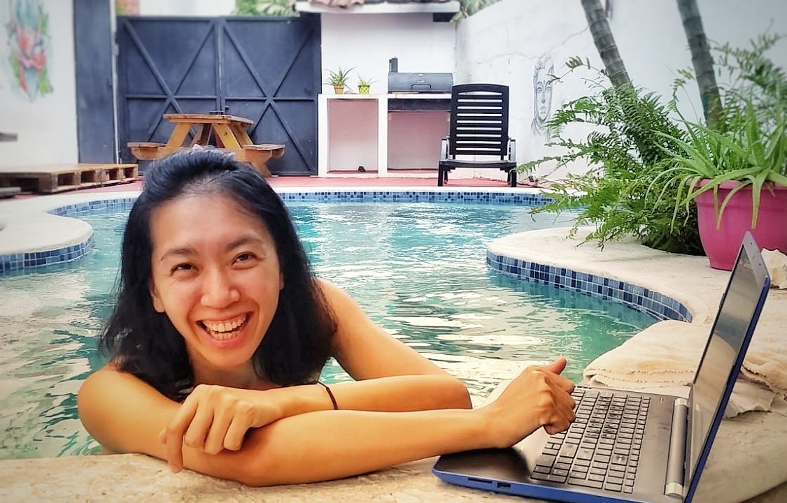 digital nomad working on a laptop in a swimming pool Casa Areka hostel數位遊牧生活蜜月期